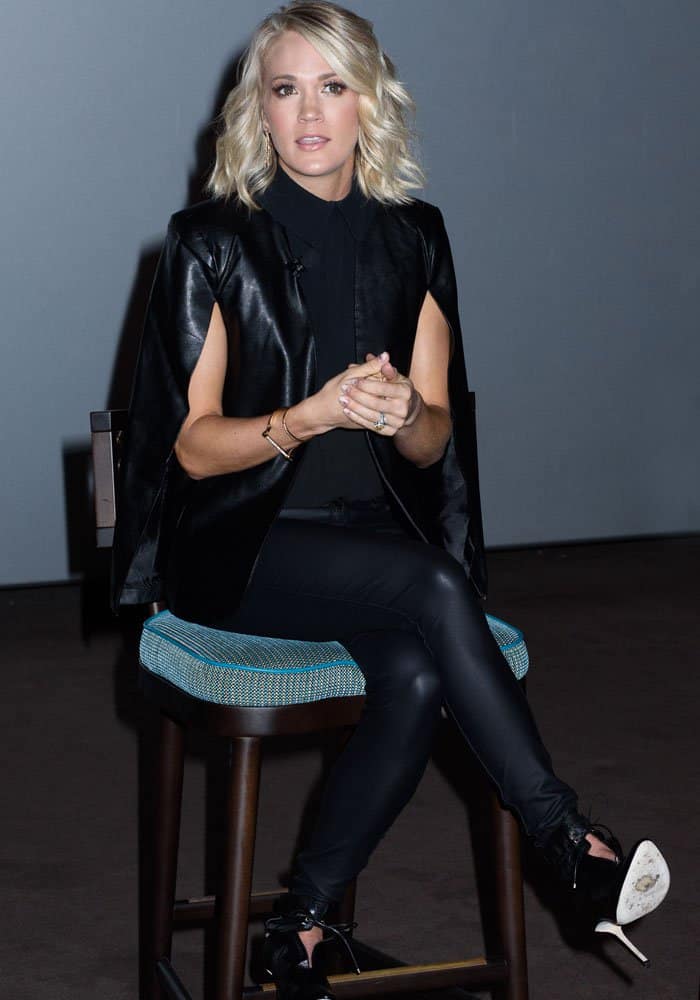 Carrie Underwood rocks an all-black ensemble featuring a sleek leather cape, fitted pants, and edgy Jimmy Choo "Murphy" boots for Carnival Vista