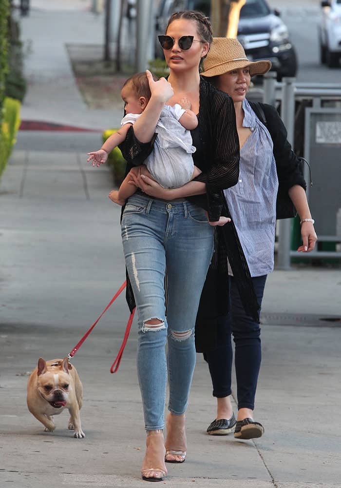 Chrissy Teigen teamed her sexy top with a sheer black cardigan and slim-fit ripped jeans