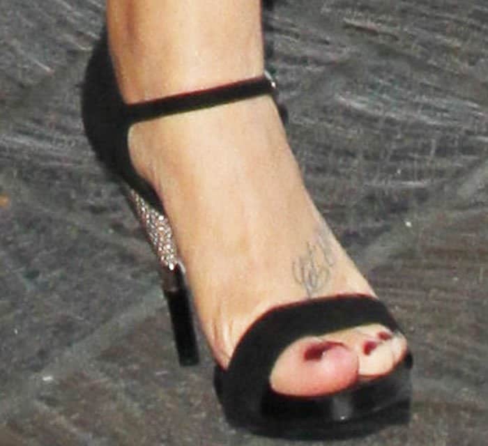 Demi Lovato showcases her chic pedicure and ankle tattoo while sporting elegant black crystal-embellished heels