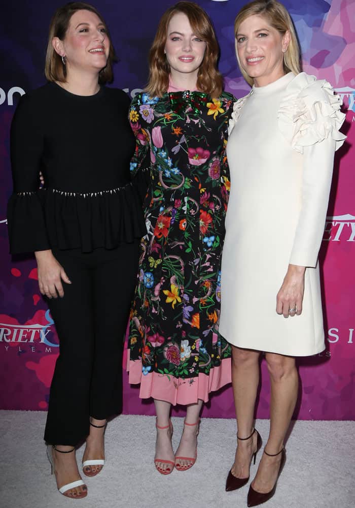 Emma Stone cozies up to her longtime glam squad—makeup artist Rachel Goodwin in two-tone ankle-strap heels and stylist Petra Flannery in sleek burgundy pointed-toe pumps—as the trio celebrates their decade-long red carpet collaboration