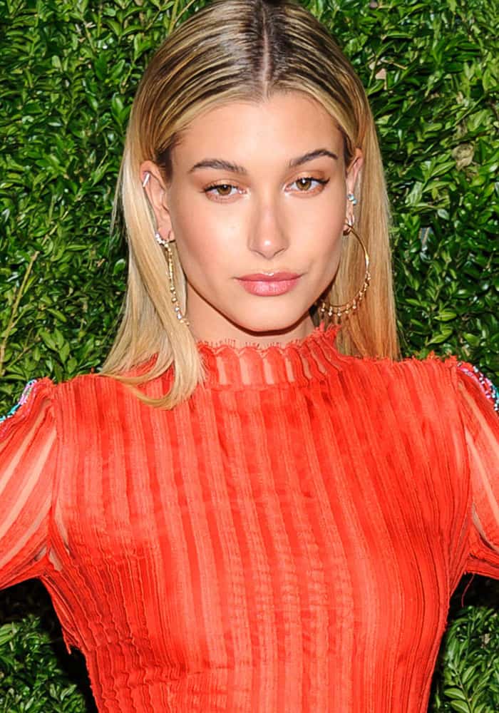 Hailey Baldwin stuns in a sheer tangerine Baja East creation, paired with Jacquie Aiche jewelry, at the CFDA/Vogue Fashion Fund Awards