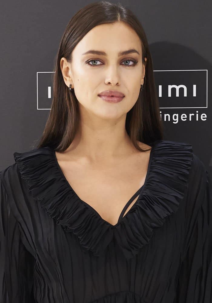 Irina Shayk showcases her striking green eyes and sleek, straight hairstyle while attending the Intimissimi event