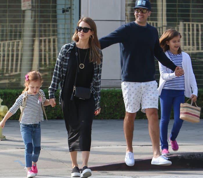 Jessica Alba steps out for a family breakfast in West Hollywood, pairing her casual black midi dress and plaid shirt with Vince "Warren" slip-on sneakers, while her husband, Cash Warren, and daughters complete the coordinated outing