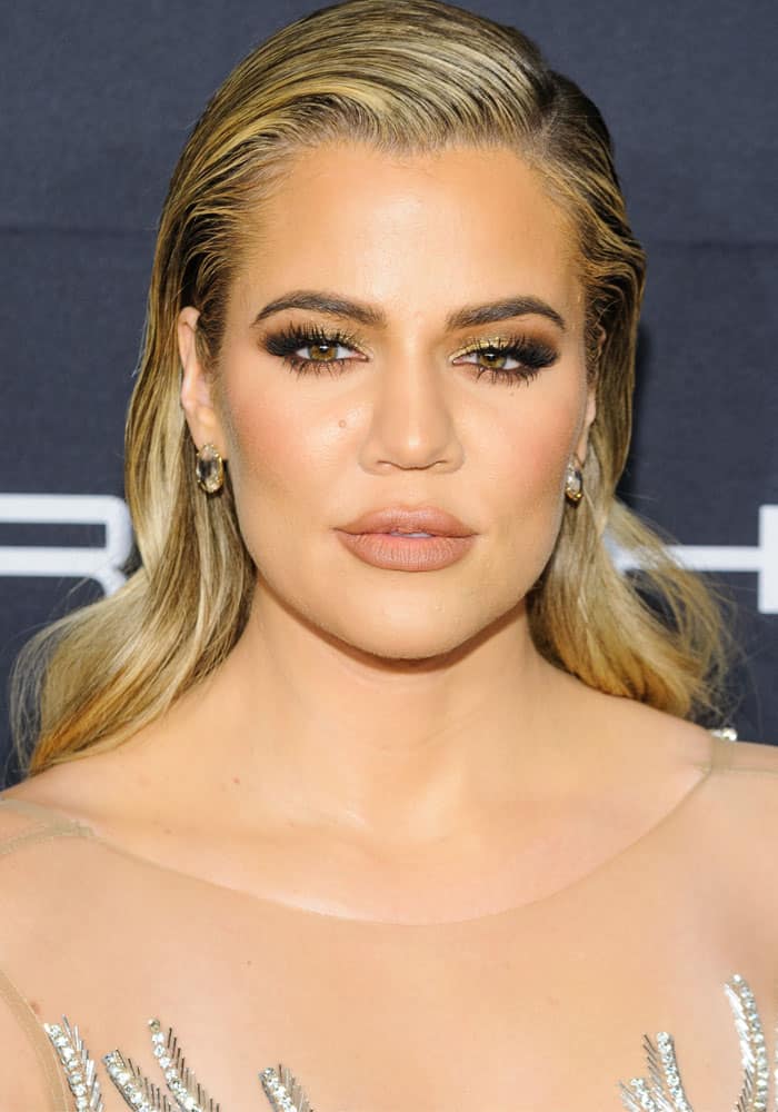 Khloé Kardashian stuns in a sheer embellished gown with metallic details at the Gabrielle's Angel Ball, complementing her bold makeup look and sleek hairstyle