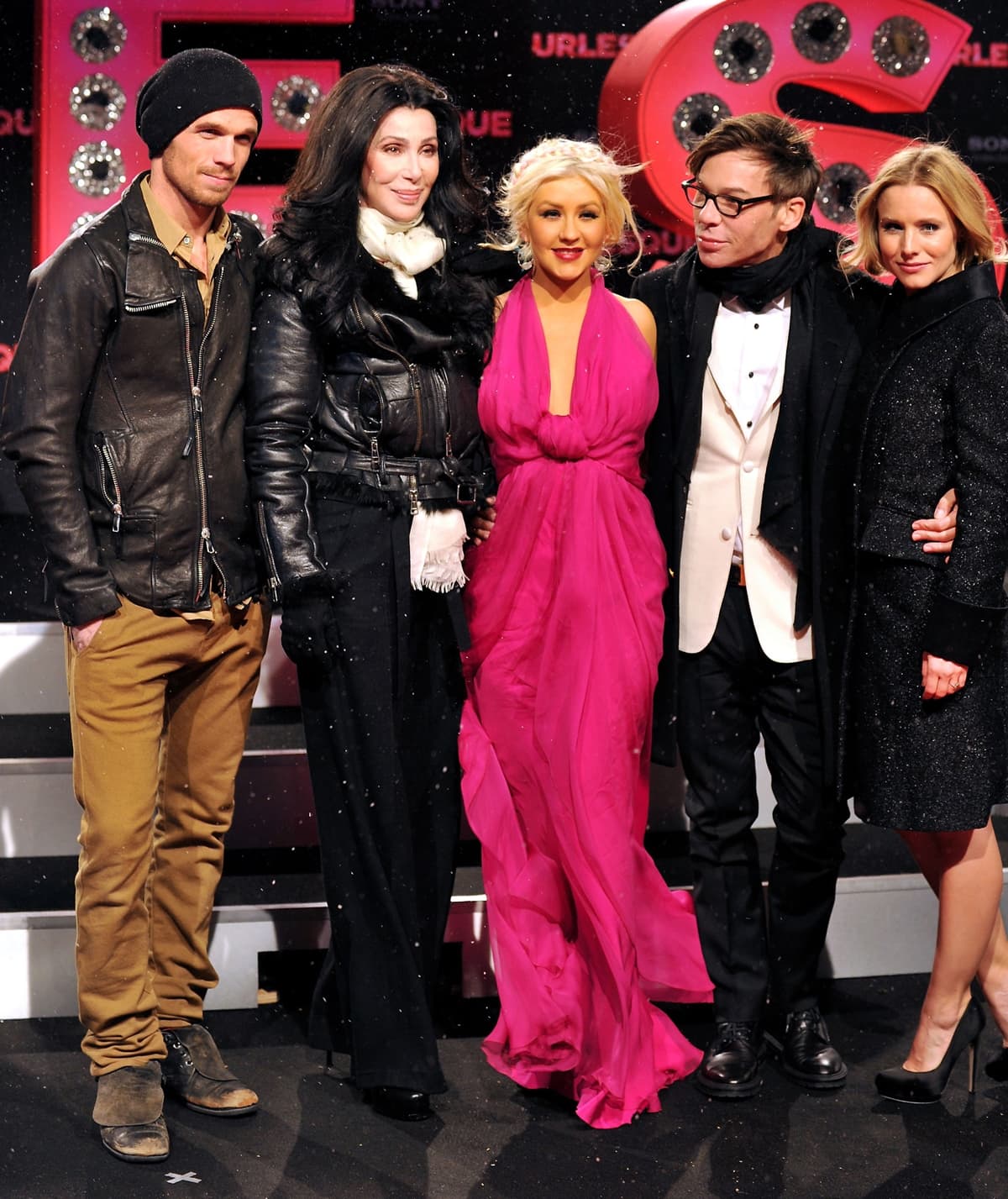 Cam Gigandet, Cher, Christina Aguilera, Steven Antin, and Kristen Bell brave the Berlin winter at the Burlesque Germany premiere on December 16, 2010—Cher’s heeled boots, Aguilera’s hidden platforms under flowing pink chiffon, and Bell’s classic pointed-toe pumps add a stylish touch to their cold-weather looks