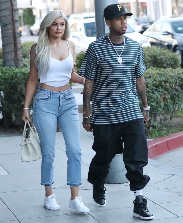 Kylie Jenner steps out in a casual chic look, pairing high-waisted jeans and a white crop top with Puma sneakers and a white Hermès Birkin bag alongside Tyga for a lunch date