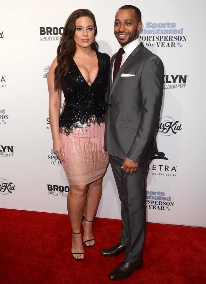 Ashley Graham poses with her husband, Justin Ervin, looking stunning in her two-toned sequin dress while he complements her in a sharp gray suit