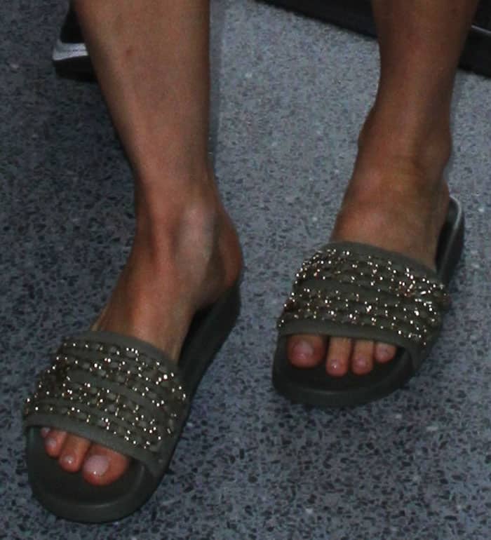 Fergie shows off her chic olive green Chanel slides adorned with gold chain details, complemented by a natural pedicure