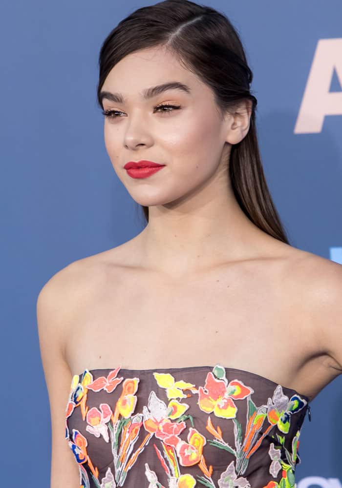 Hailee Steinfeld stuns with sleek, side-parted hair and a bold red lip, perfectly complementing her strapless floral gown at the 2016 Critics' Choice Awards