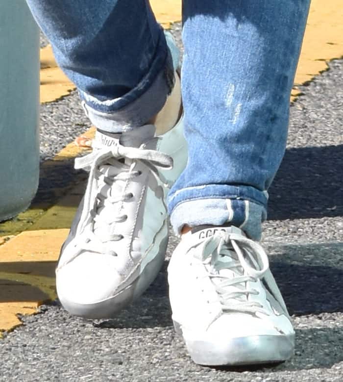 Hilary Duff is wearing Golden Goose Deluxe Brand "Super Star" sneakers paired with distressed blue jeans cuffed at the ankles