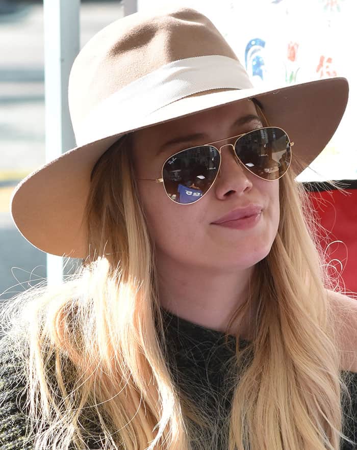 Hilary Duff accessorized her casual look with a chic Panama-style hat and Ray-Ban aviator sunglasses
