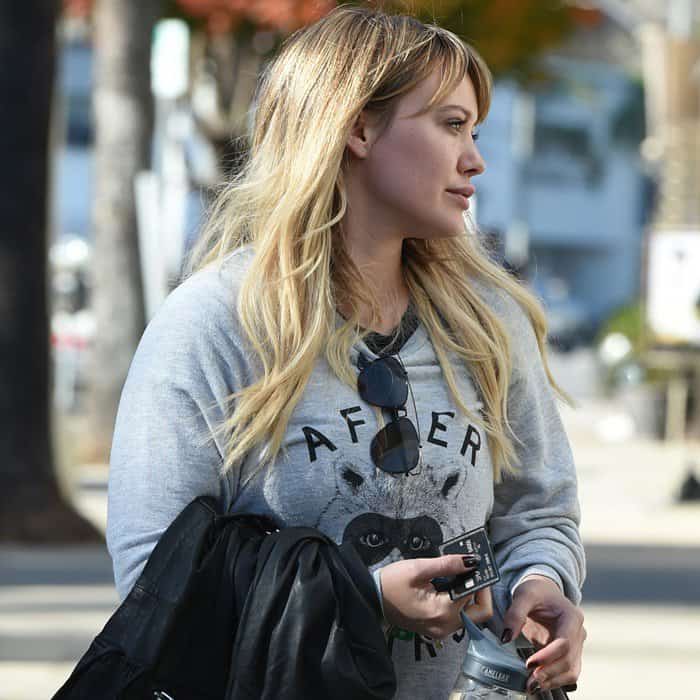 Hilary Duff steps out in a cozy A Fine Line sweatshirt featuring a raccoon graphic while keeping it casual with sunglasses and a water bottle in hand