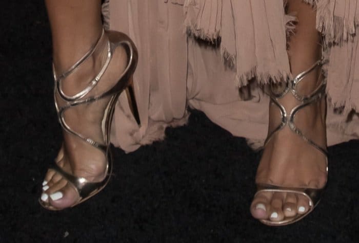Karrueche Tran shows off her feet in wavy-strap sandals in bronze