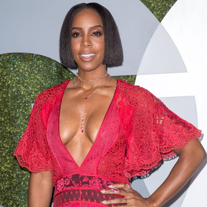 Kelly Rowland shows off a sleek bob hairstyle while confidently flaunting a daring plunging neckline in her red lace gown