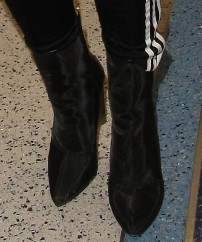 Khloé Kardashian wears a pair of Yeezy women's black leather-trimmed mesh ankle boots