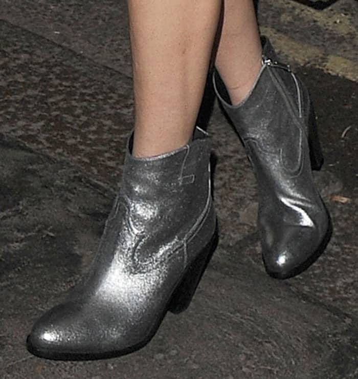 Lady Gaga in silver Saint Laurent ankle boots featuring a sleek metallic finish, side pull tabs, and a three-inch stacked heel for a bold statement