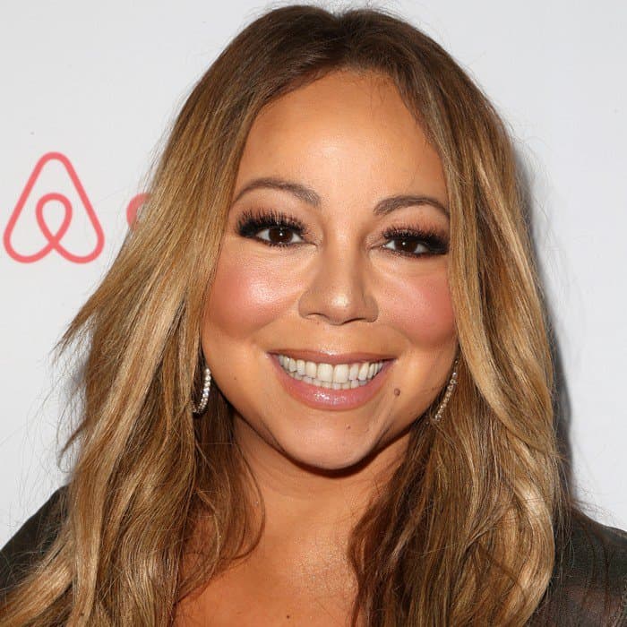 Mariah Carey has warm brown eyes and honey-blonde hair styled in loose waves