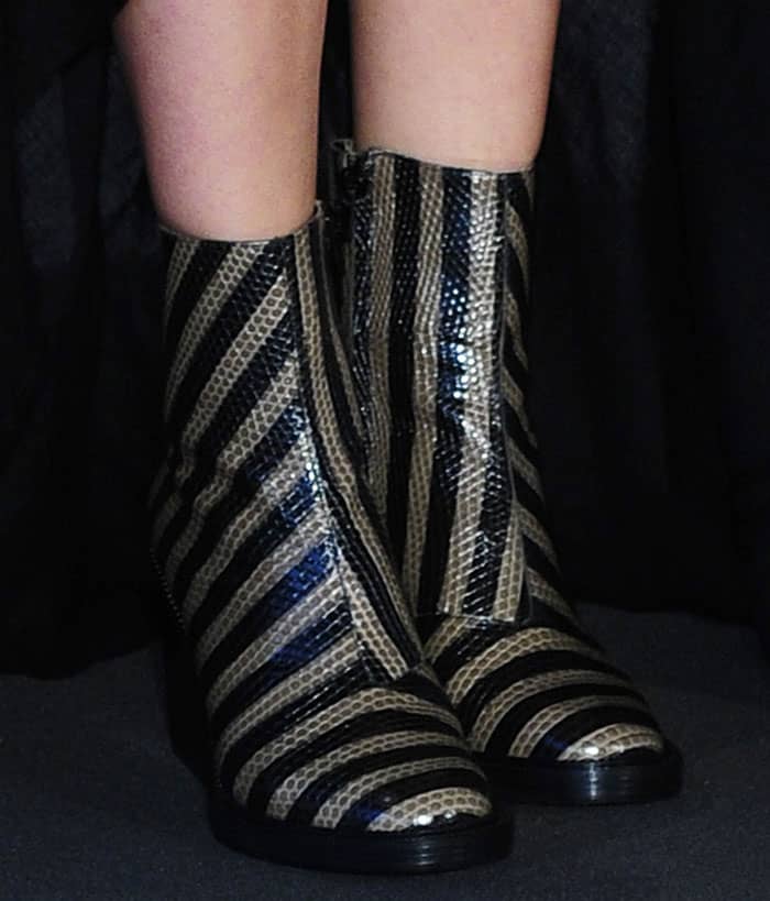 Marion Cotillard's striking boots feature a bold two-tone striped design crafted from lizard-effect leather, with side-zip fastenings and sturdy three-inch heels