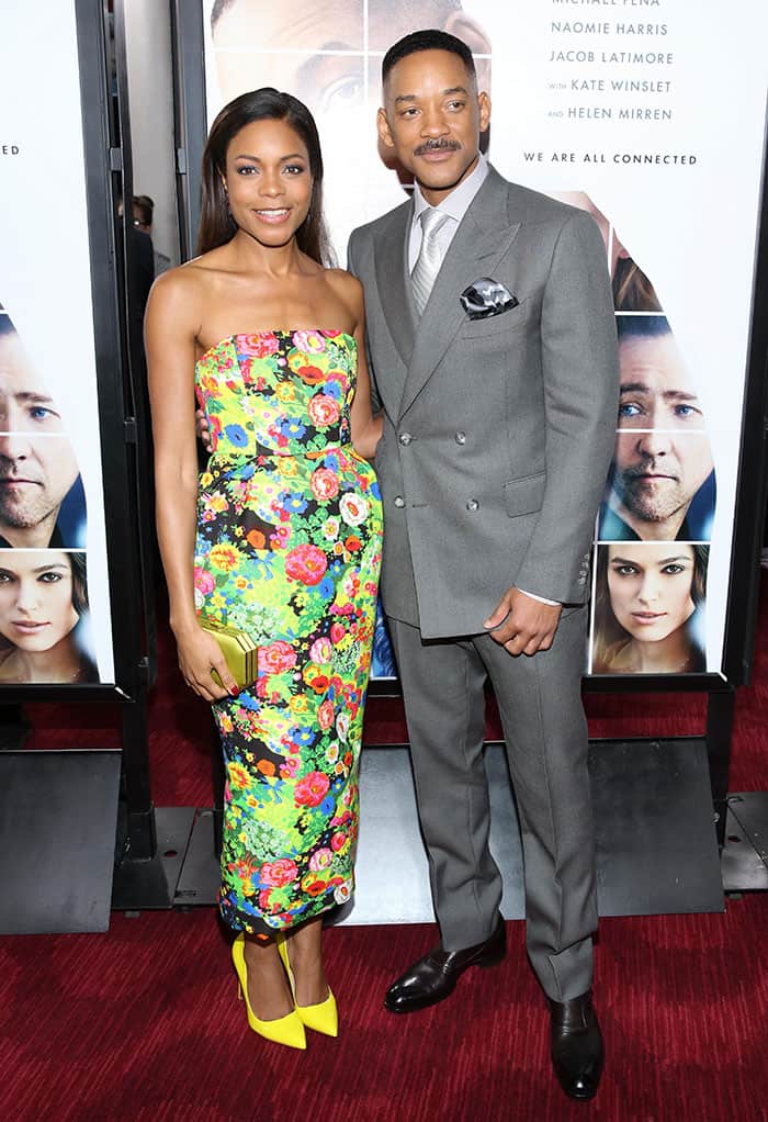 Will Smith complemented Naomie Harris’ vibrant floral look in a sharply tailored grey Tom Ford double-breasted suit, pairing the refined silhouette with a light grey dress shirt, silver silk tie, patterned pocket square, and polished black leather Tom Ford loafers at the Collateral Beauty New York premiere at Lincoln Center on December 12, 2016
