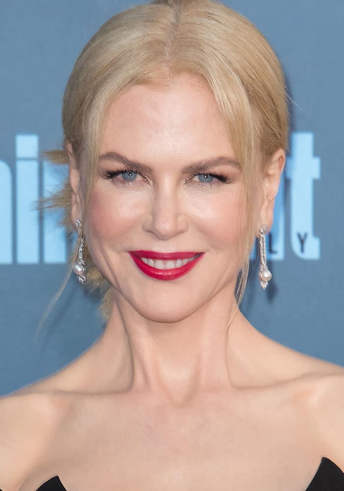 Nicole Kidman shines with bold red lips, a sleek updo hairstyle, and elegant drop earrings that enhance her red carpet glamour at the 2016 Critics' Choice Awards