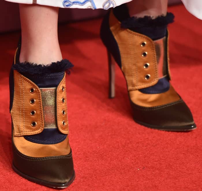 Olivia Palermo effortlessly pulled off the Jimmy Choo 'Mitsu' booties, featuring bold military-inspired detailing, striking metallic panels, and luxurious burnt orange and navy hues, making them a standout choice for the red carpet