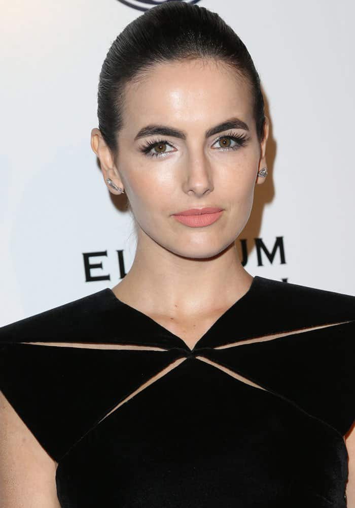 Camilla Belle kept her look elegant and polished with a sleek updo, minimalistic makeup emphasizing bold brows and a soft lip, and subtle diamond stud earrings to complement her sophisticated style at the Art of Elysium's gala "Stevie Wonder's Heaven"