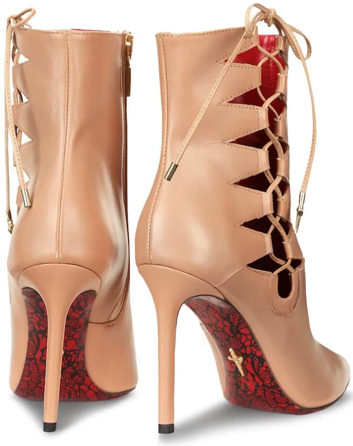 Cesare Paciotti’s ‘Sveva’ booties stand out with their signature red sole adorned with intricate lace-like detailing and the brand’s iconic dagger logo, showcasing unmistakable luxury