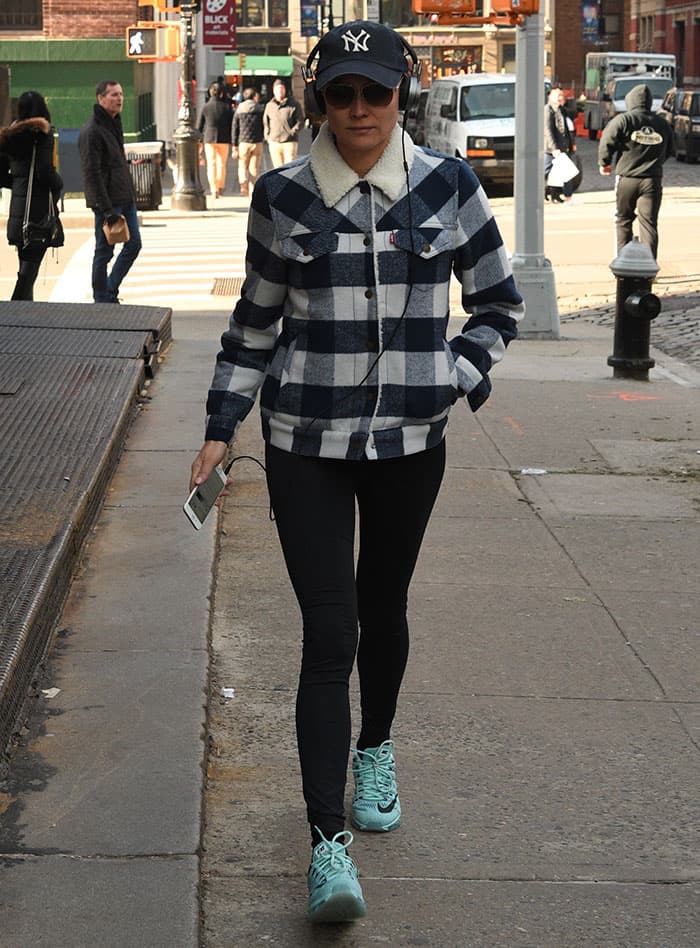 Diane Kruger effortlessly nails casual street style with a checkered Levi's jacket, black leggings, and striking Nike Air Max sneakers