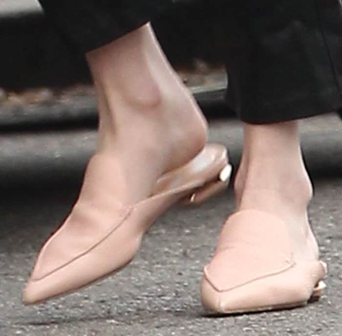 Emma Roberts steps out in chic blush-colored slip-on mules featuring a pointed toe and subtle gold detailing on the heel