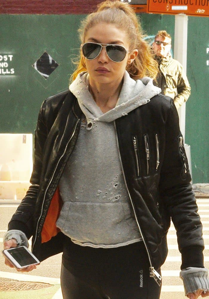 Gigi Hadid wears sleek Reebok Speedwick capri leggings with a The New Designers Fame black bomber jacket and a Reebok Hero Rebel bra