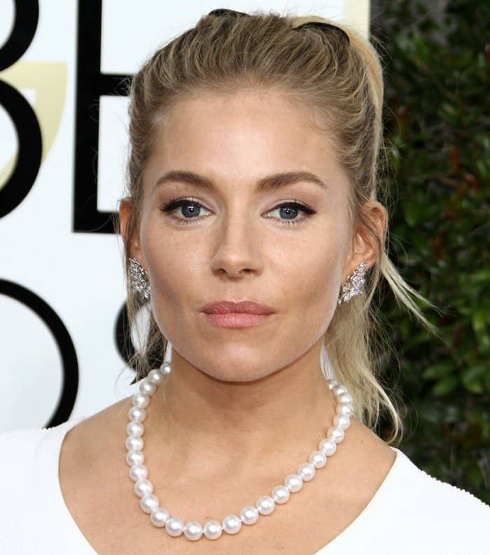 Sienna Miller pairs her elegant pearl necklace with statement diamond earrings