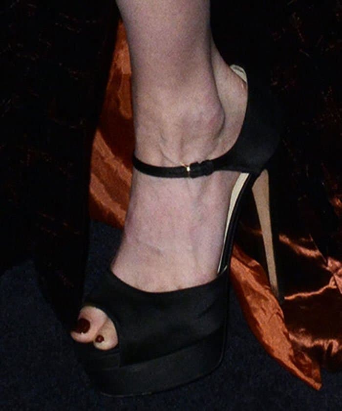 Greta Gerwig completes her look with a sleek pedicure and classic black satin platform sandals