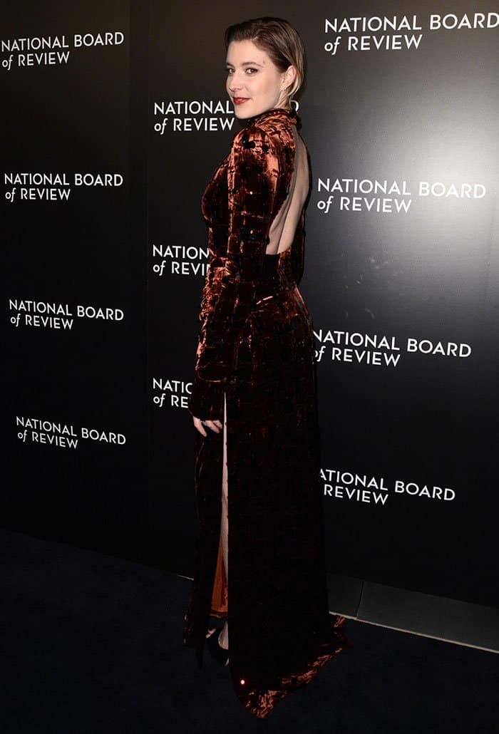 Greta Gerwig stuns in a Prada velvet dress featuring a bold cutout back and a thigh-high slit