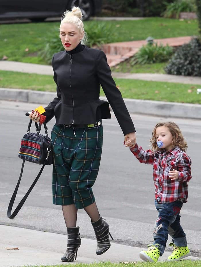 Gwen Stefani steps out in Los Angeles on January 15, 2017, pairing striped pointed-toe stiletto booties with plaid culottes and a structured black jacket while holding hands with her son, Apollo Rossdale