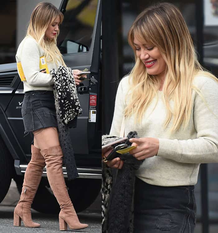 Hilary Duff complements her casual chic outfit with soft, natural waves in her blonde hair, a radiant red lipstick for a pop of color, and minimal accessories to keep the look effortless yet polished