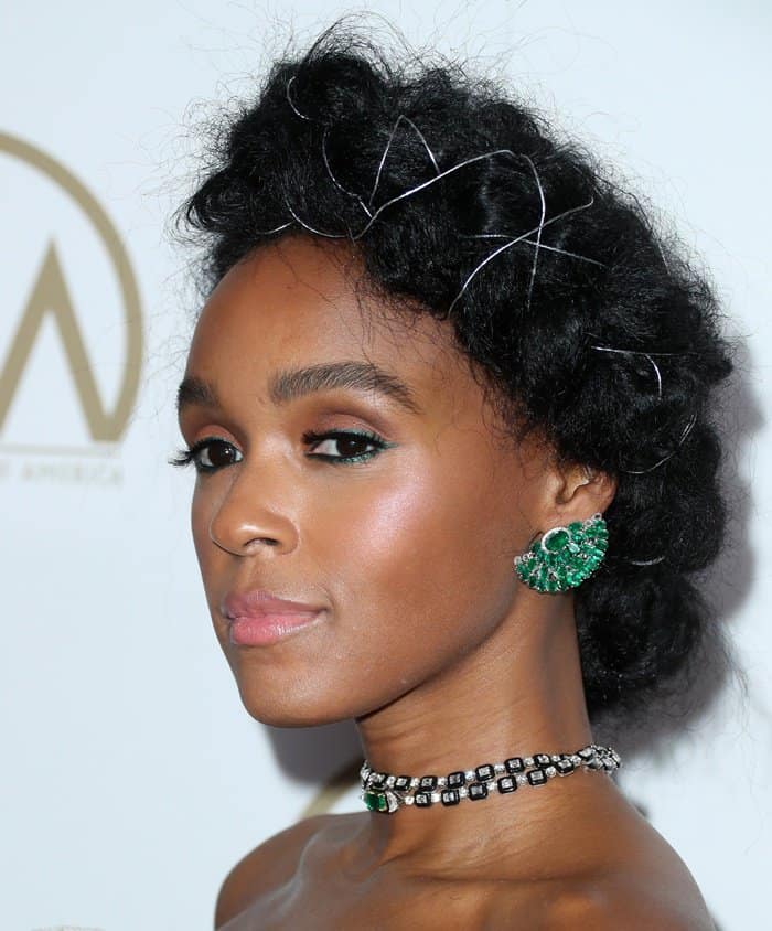 Janelle Monáe's emerald drop earrings and intricate choker featuring a mix of green gemstones and diamonds added a vibrant pop of color