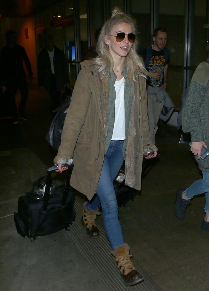 Julianne Hough nails casual airport style with a khaki parka, white tee, skinny jeans, and fur-trimmed duck boots—proving cozy can still be chic!