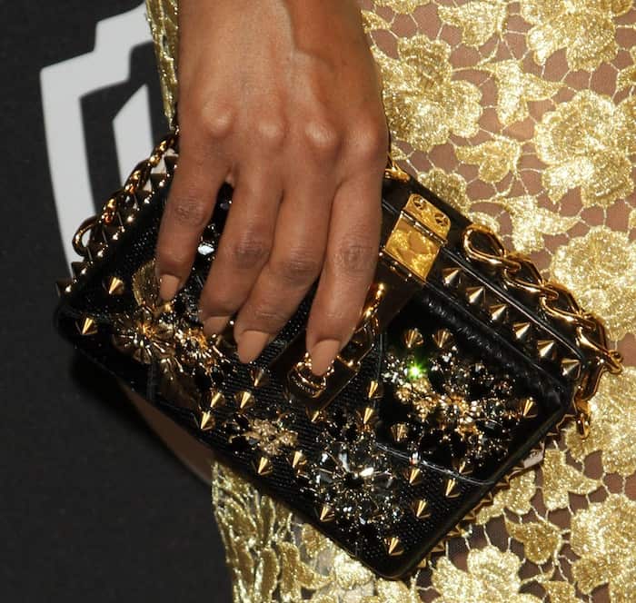 Kerry Washington adds edge to her ensemble with a studded Dolce Gabbana clutch complemented by a nude manicure