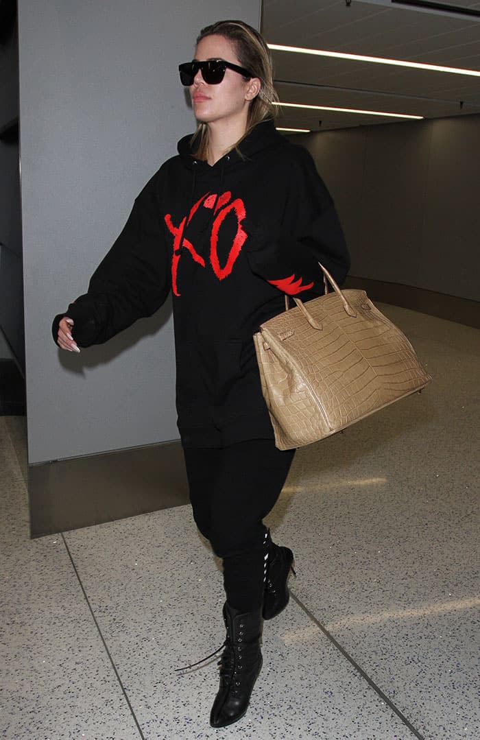 Khloé Kardashian is effortlessly striding through LAX, exuding confidence and ease while navigating the airport in her cozy yet chic ensemble