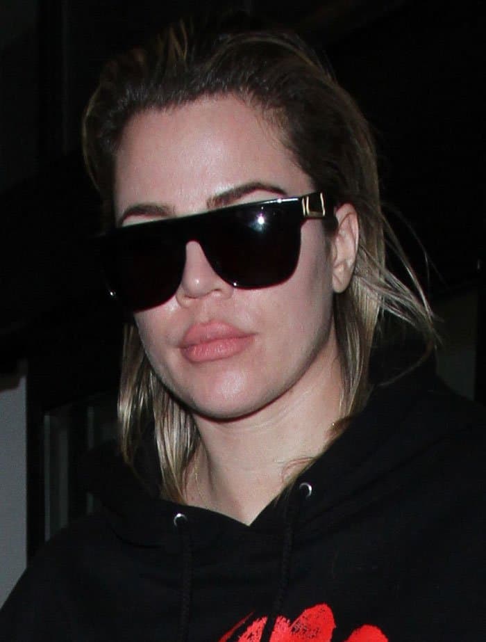Khloé Kardashian completes her casual look with oversized black sunglasses and a natural makeup vibe, highlighting fresh skin and a subtle nude lip