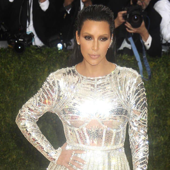 Kim Kardashian rocks a sleek, slicked-back hairstyle, bold contouring makeup, and minimal jewelry