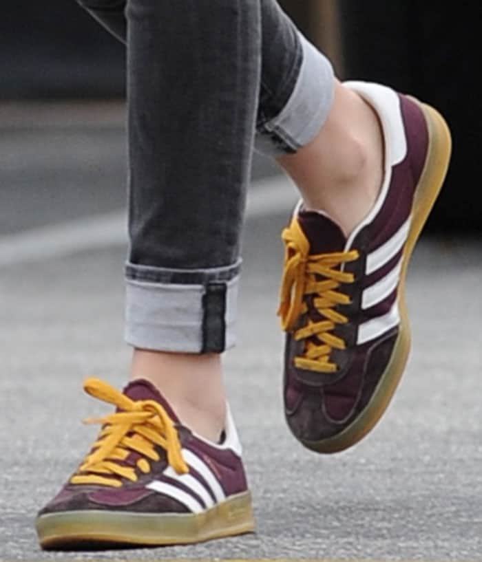 Kristen Stewart’s maroon Adidas Gazelle sneakers, featuring bold yellow laces and a classic gum sole, showcase the timeless appeal and versatility that make Gazelles a favorite among celebrities for casual, stylish looks