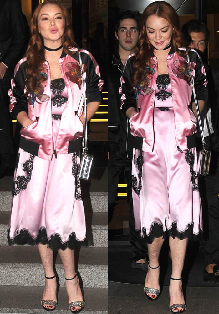 Lindsay Lohan showcases chic sleepwear-inspired fashion with a pink silk and lace dress, embroidered bomber jacket, and glittery ankle-strap heels during Milan Fashion Week