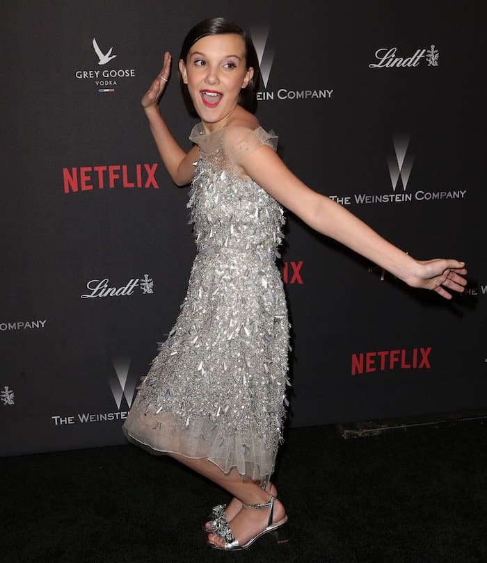 Millie Bobby Brown has fun in a sweet silver dress and matching shoes