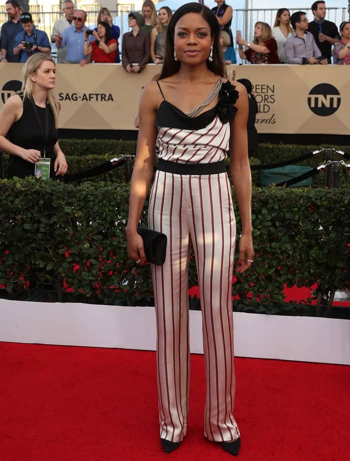 Naomie Harris demonstrates how to elevate a bold striped jumpsuit with structured accessories and elegant pointy-toe pumps for a polished red carpet look