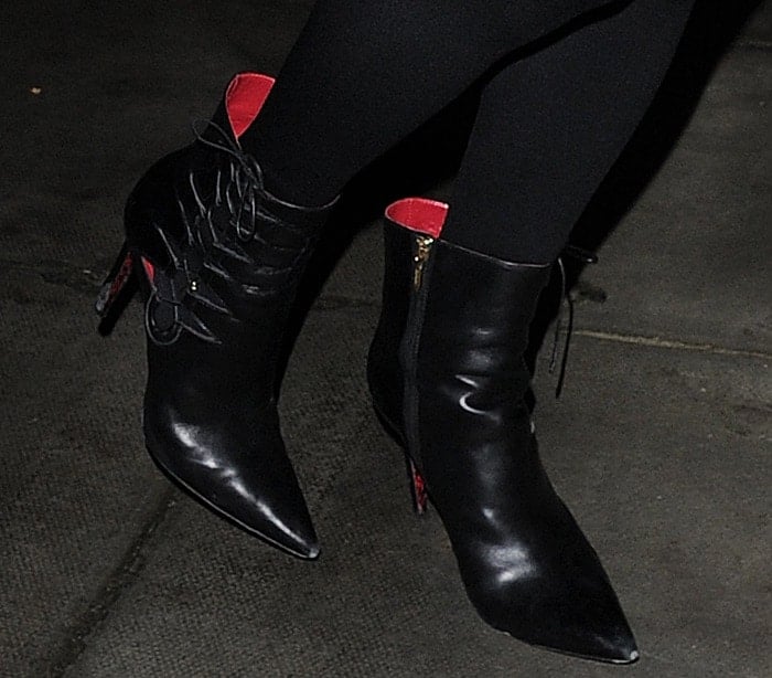 Paris Hilton steps out in sleek Cesare Paciotti leather booties featuring pointed toes, lace-up detailing, and bold red accents, perfectly complementing her polished look