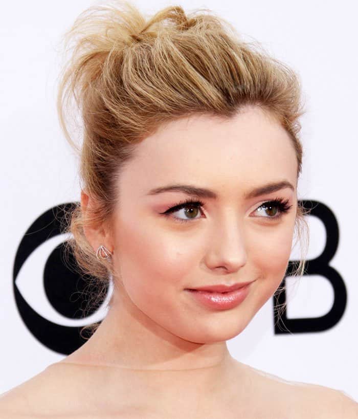 Peyton List glows with soft pink makeup and a textured updo that highlights her youthful, red-carpet elegance