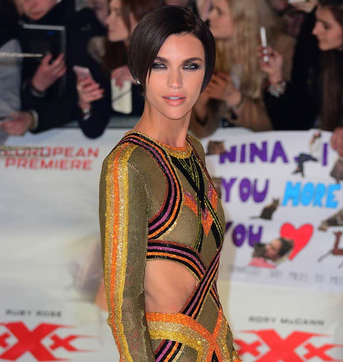 Ruby Rose exuded confidence with a sultry expression, highlighting her sleek, side-parted bob hairstyle and vibrant, patterned gown