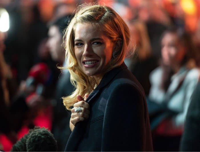 Sienna Miller covered up in the chilly London night for the interviews