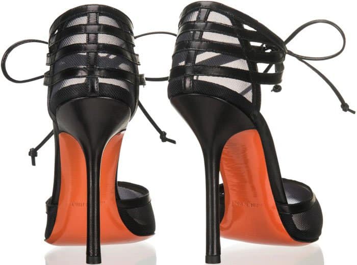 The rear angle emphasizes the sculptural stiletto and cage-style ankle straps, revealing the contrast between opaque leather and translucent mesh